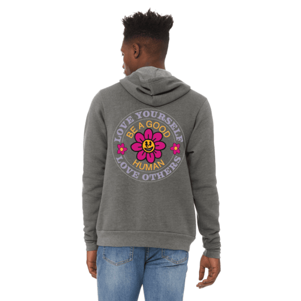 A man wearing jeans and a hoodie with a flower on it.