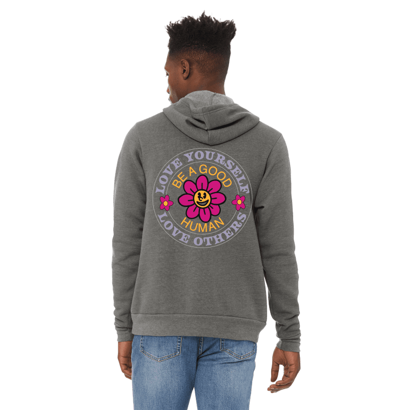 A man wearing jeans and a hoodie with a flower on it.